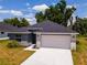 One-story home with gray exterior, stone accents, and a two-car garage at 43 S Kentucky Ave, Umatilla, FL 32784