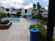 Community pool with lounge chairs and umbrellas at 3480 Soho St # 101, Orlando, FL 32835