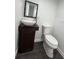 Modern bathroom with pedestal sink, toilet, and dark floors at 1526 Lakewood Rd, Davenport, FL 33837