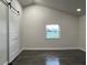 Bright bedroom featuring a barn door and dark laminate flooring at 1526 Lakewood Rd, Davenport, FL 33837