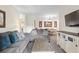 Living room with grey sofas, coffee table and view into dining area at 1370 Tuscan Terrace # 2205, Davenport, FL 33896