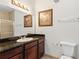 Bathroom with granite countertop, dark wood cabinets, and a shower at 1370 Tuscan Terrace # 2205, Davenport, FL 33896