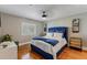 Serene bedroom with hardwood floors, blue upholstered bed, and window shutters at 9227 Cypress Cove Dr, Orlando, FL 32819