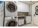 Bright laundry room with washer, dryer, and ample counter space at 9227 Cypress Cove Dr, Orlando, FL 32819