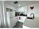 Well-equipped galley kitchen with white cabinetry and quartz countertops at 6165 Carrier Dr # 3802, Orlando, FL 32819