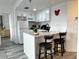 Modern kitchen with white cabinets, quartz countertops, and breakfast bar at 6165 Carrier Dr # 3802, Orlando, FL 32819