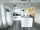 White kitchen with an island, stainless steel appliances, and subway tile backsplash at 6165 Carrier Dr # 3802, Orlando, FL 32819