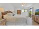 King-size bed with wooden headboard in bright main bedroom at 4407 Sea Mist Ct # 267, New Smyrna Beach, FL 32169