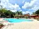 Refreshing community pool surrounded by palm trees and lounge chairs at 837 Grand Regency Pt # 207, Altamonte Springs, FL 32714