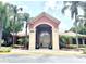 Gated entrance to Crescent Place Condominiums, featuring a brick building and lush landscaping at 837 Grand Regency Pt # 207, Altamonte Springs, FL 32714