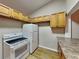 Kitchen with wood cabinets, white appliances, and wood flooring at 424 E Welch Rd, Apopka, FL 32712