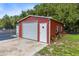 Red metal garage with roll-up door and side entry at 424 E Welch Rd, Apopka, FL 32712