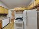 Kitchen with wood cabinets, white appliances, and wood flooring at 424 E Welch Rd, Apopka, FL 32712