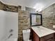 Updated bathroom with stone-look tile and tub shower at 424 E Welch Rd, Apopka, FL 32712