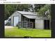 Tan metal garage with attached shed and gated yard at 3060 Rambler Ave, Saint Cloud, FL 34772
