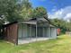 Brown metal barn with covered stalls and gravel flooring at 3060 Rambler Ave, Saint Cloud, FL 34772