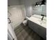 Modern bathroom with gray vanity, white bathtub, and gray wood-look floors at 3561 Conroy Rd # 227, Orlando, FL 32839