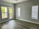 Primary bedroom with wood-look floors, sliding glass doors and two windows at 3561 Conroy Rd # 227, Orlando, FL 32839