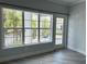 Living room with large windows offering natural light and balcony access at 3561 Conroy Rd # 227, Orlando, FL 32839