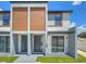 Modern townhome with gray and wood siding, two private entrances, and landscaping at 3229 Energy Dr, Kissimmee, FL 34747