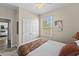 Bedroom with a queen bed, ceiling fan, double doors and window at 8100 Princess Palm Ln # 201, Kissimmee, FL 34747