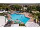 Large community pool with plenty of lounge chairs and umbrellas at 8100 Princess Palm Ln # 201, Kissimmee, FL 34747