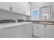 Bright laundry room, featuring modern washer and dryer, and ample cabinetry at 2234 Via Luna, Winter Park, FL 32789