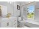 Clean bathroom with white cabinetry, gold fixtures, and a large window at 2234 Via Luna, Winter Park, FL 32789