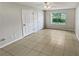 Spacious bedroom with tile flooring, double closets and a window at 5545 Devonbriar Way # I101, Orlando, FL 32822