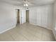 Bright bedroom with tile flooring, double door closet and ceiling fan at 5545 Devonbriar Way # I101, Orlando, FL 32822