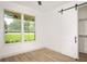 Bright bedroom featuring a barn door and wood-look floors at 19906 Eldorado Dr, Eustis, FL 32736