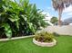 Landscaped backyard with artificial turf, raised garden beds, and lush tropical plants at 342 Maple Dr, Longwood, FL 32750