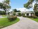 Single-story home with circular driveway, manicured landscaping, and palm trees at 342 Maple Dr, Longwood, FL 32750