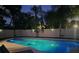 Inviting backyard pool at night with surrounding fence and palm trees at 342 Maple Dr, Longwood, FL 32750