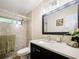 Bathroom with walk-in shower, dark vanity, and quartz countertop at 342 Maple Dr, Longwood, FL 32750