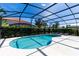 Relaxing kidney-shaped pool with covered lanai and patio furniture at 4036 Oakrise Loop, Davenport, FL 33837