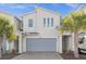 Modern house exterior with gray garage door and landscaping at 3387 Beaute Dr, Kissimmee, FL 34746