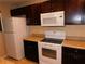 White appliances and dark wood cabinets in this galley style kitchen at 200 Afton Sq # 102, Altamonte Springs, FL 32714
