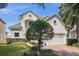 Two story house with white exterior, grey tile roof, and landscaping at 8629 Saint Marino Blvd, Orlando, FL 32836