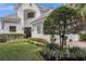 Two-story home with white exterior, gray tile roof, and landscaped yard at 8629 Saint Marino Blvd, Orlando, FL 32836