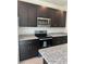 Dark wood cabinets, granite countertops, and stainless steel appliances at 6952 Sw 152Nd St, Ocala, FL 34473
