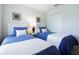 Two twin beds with blue bedding and nightstands in a bright bedroom with a closet at 244 Capri Dr, Davenport, FL 33897