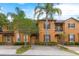 Townhouse with orange exterior and lush landscaping at 244 Capri Dr, Davenport, FL 33897