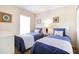 Two twin beds with blue bedding and nightstands in a bright bedroom at 244 Capri Dr, Davenport, FL 33897