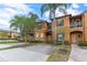Two-story tan building with palm trees and brick driveway at 244 Capri Dr, Davenport, FL 33897