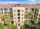 An elevated view of a yellow building with brown roofs and palm trees at 8801 Worldquest Blvd # 4406, Orlando, FL 32821