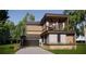 Two-story modern home with wood and concrete accents, balcony, and attached garage at 627 Country Club Dr, Winter Park, FL 32789