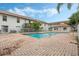 Community pool with brick patio and surrounding buildings at 3651 N Goldenrod Rd # B107, Winter Park, FL 32792