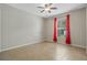 Bright bedroom with tile floor, ceiling fan, and red curtains at 3651 N Goldenrod Rd # B107, Winter Park, FL 32792