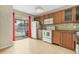 Kitchen boasts wood cabinets, white appliances, and access to a patio with a pool view at 3651 N Goldenrod Rd # B107, Winter Park, FL 32792